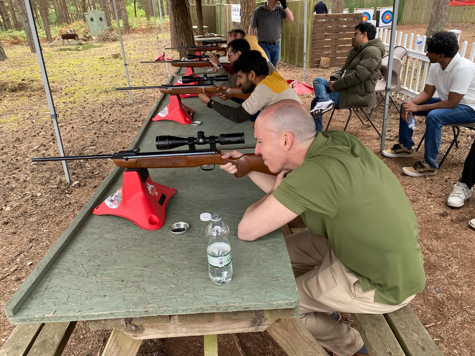 Participants shooting scoped .22 air rifles from rests at the covered range