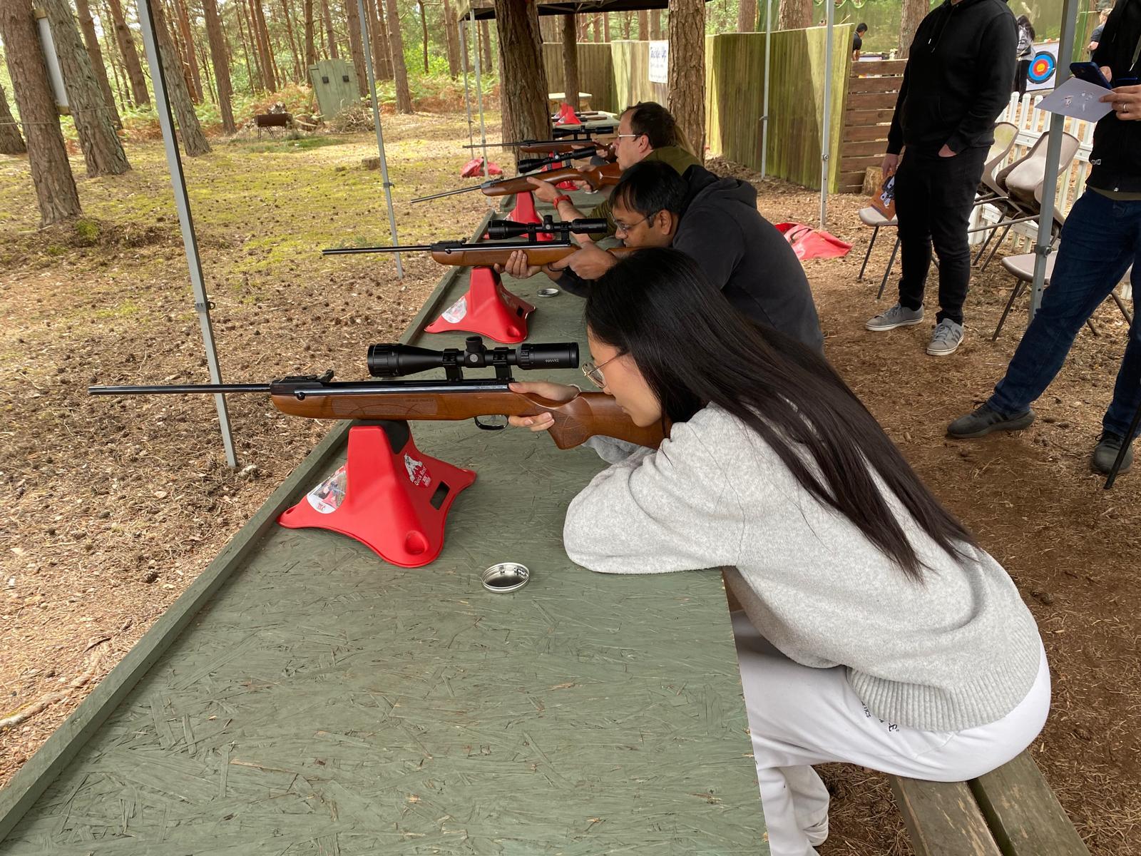 Colleagues taking part in a rifle shooting session on a corporate activity day